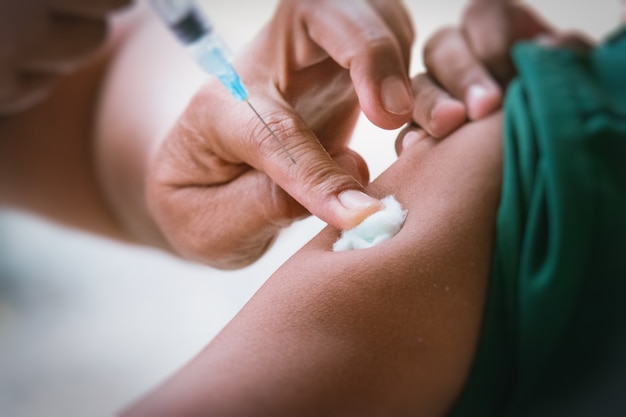 Doctor inject vaccine to patient.