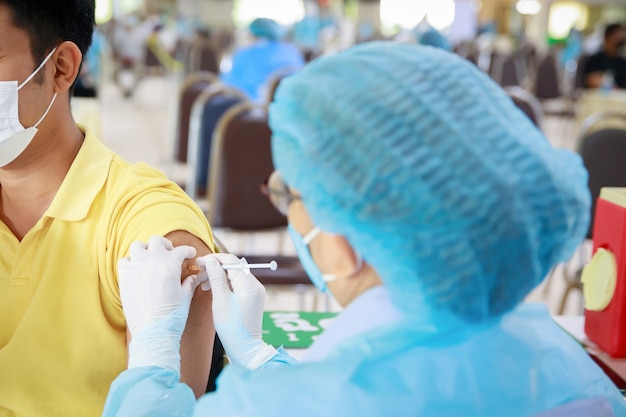 Doctor injecting flu vaccine Covid19 or flu antivirus vaccine patients arm in local hospital