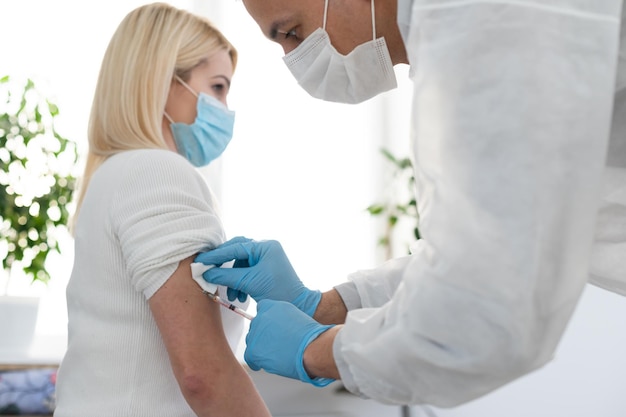 Foto medico che inietta il vaccino a una donna, vaccino covid
