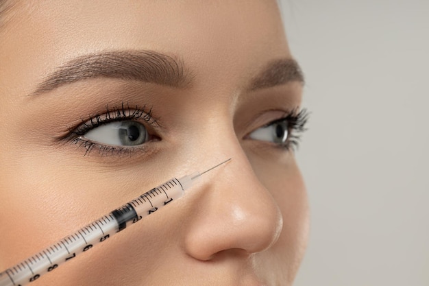 The doctor injects botox to a young girl