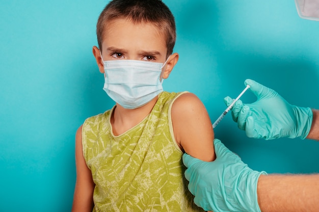 Photo doctor injects vaccine to a child against covid coronavirus