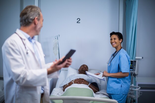 Photo doctor interacting with nurse in ward