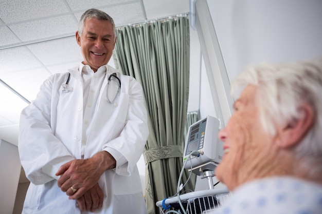 Doctor interacting with senior patient in ward