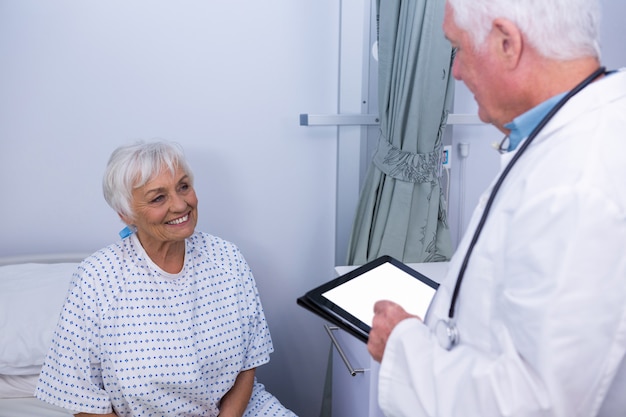 Doctor interacting with senior patient in ward