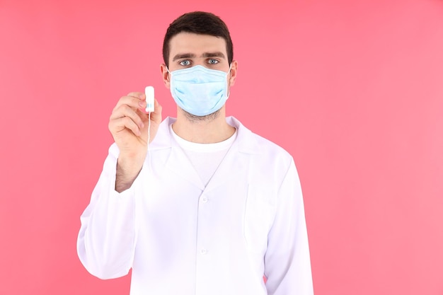 Doctor intern holds tampon on pink background