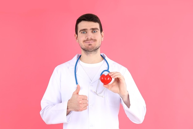 Doctor - intern with heart on pink background