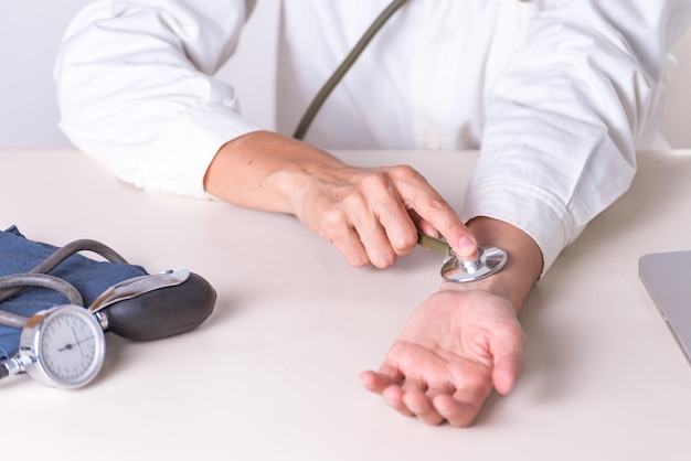 A doctor is checking a blood pressure on a table.