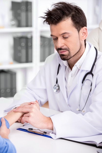 Doctor is checking patient's blood pressure in medical room.