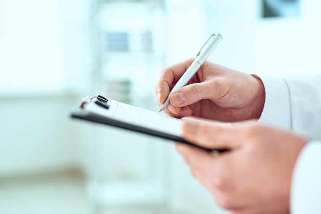 doctor is filling out the patient's registration card