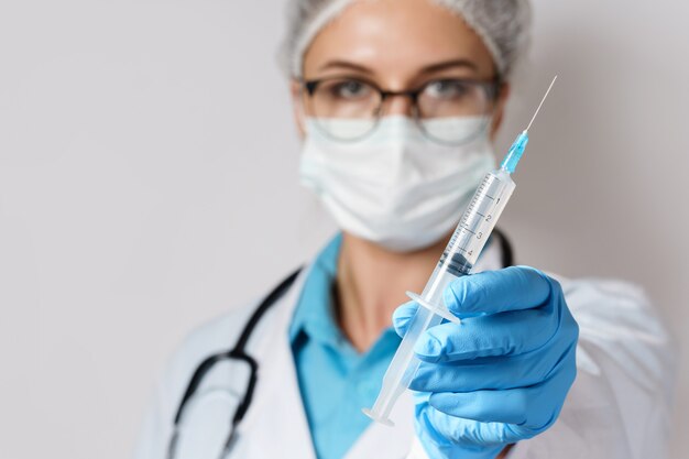 Doctor is holding syringe with a vaccine or some sort of medicine