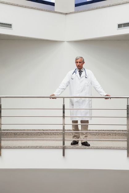 Doctor is standing at the railing of the corridor