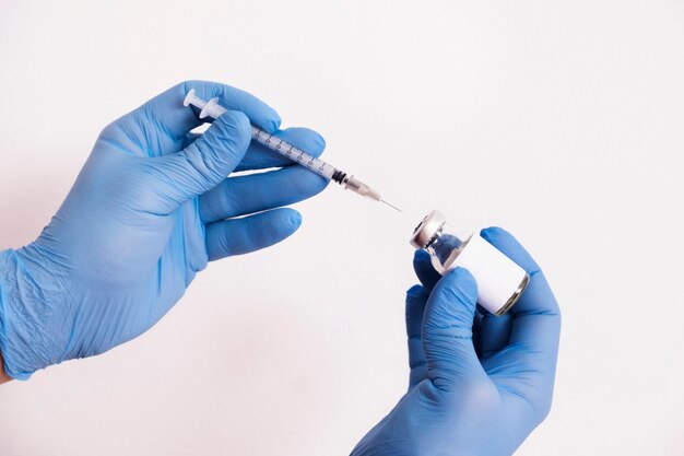 The doctor is taking an injection from the coronavirus into a syringe.