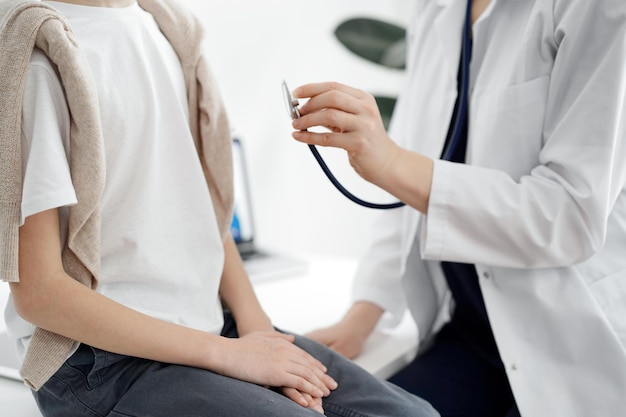 Doctor and a kid patient. Physician is holding stethoscope and ready to examine boy. Perfect health concept in medicine.