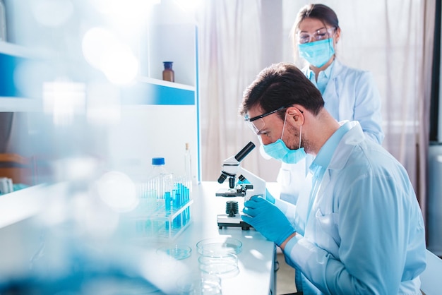 Doctor in the laboratory analyzes samples of codiv under a microscope