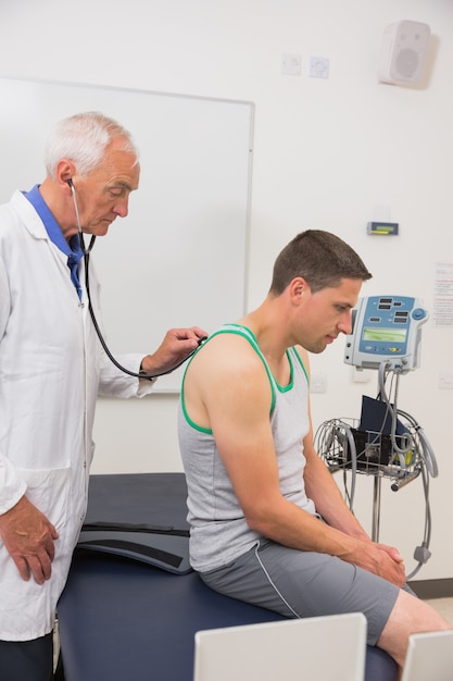 Doctor listening to patient with stethoscope