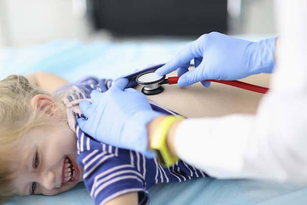 Doctor listens to little girl breathing with stethoscope.