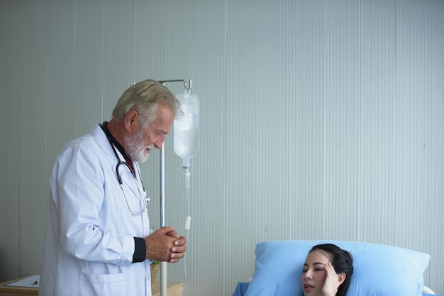 사진 병원 의 침대 에서 휴식 하는 여성 환자 를 바라보는 의사