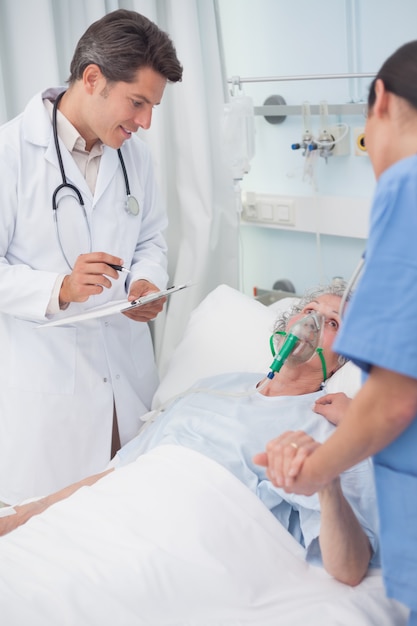 Doctor looking at patient next to a nurse