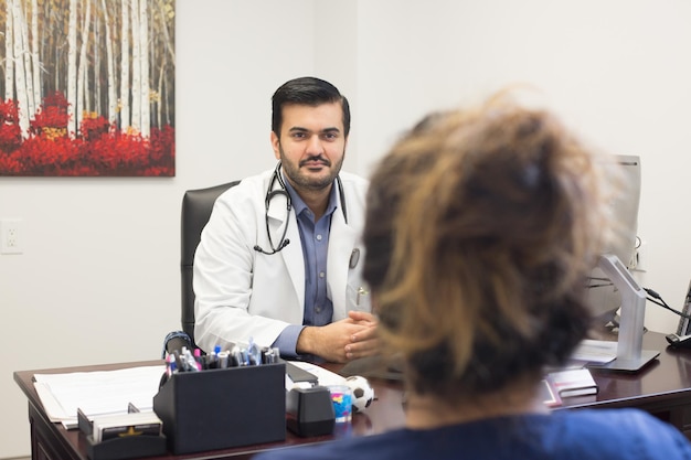 Foto il dottore guarda il paziente seduto in clinica