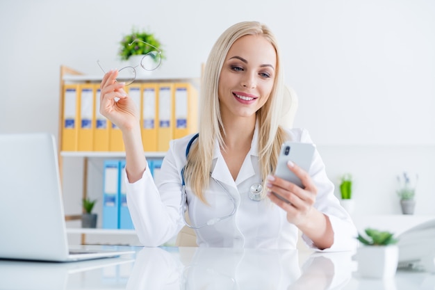 doctor looking on phone in her office