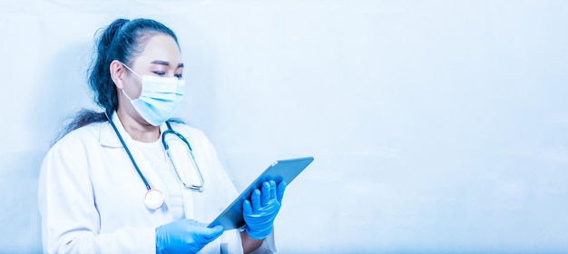 医師はタブレットの画面を見て患者の病歴を確認します 女性は医療データを分析する近代的な病院機器を握っています 選択的なフォーカスぼんやりした背景技術