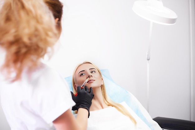 Доктор делает красивую инъекцию гиалуроновой губы для сексуальных губ девушки