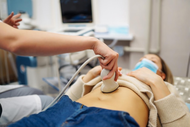 Doctor makes patient women abdominal ultrasound Ultrasound Scanner in hands of doctor Diagnostics