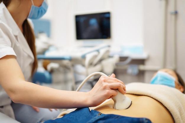 Doctor makes patient women abdominal ultrasound Ultrasound Scanner in hands of doctor Diagnostics