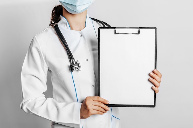 Doctor in mask with stethoscope and documents on white isolated background