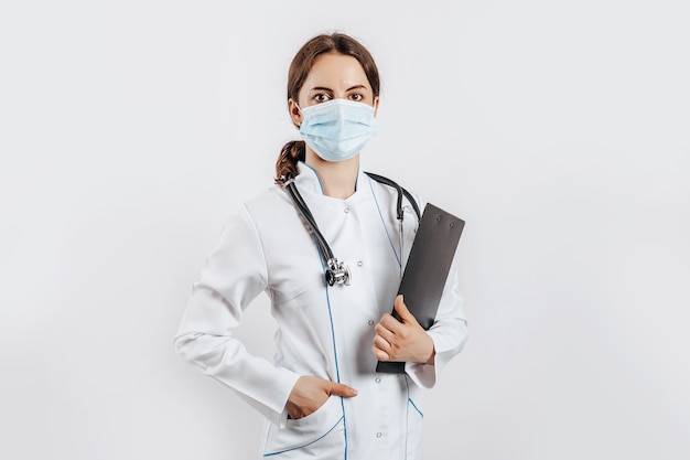 Doctor in mask with stethoscope and documents on white isolated space