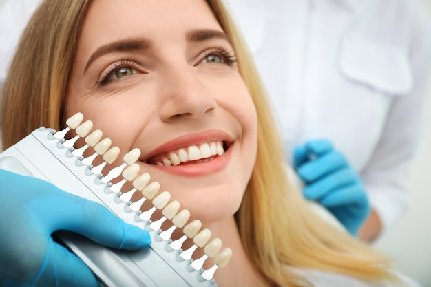 Photo doctor matching patient's teeth color with palette closeup cosmetic dentistry