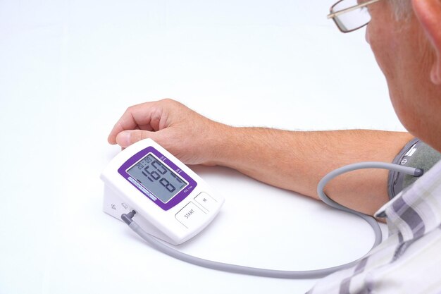 Врач измеряет артериальное давление пациента. У пожилого мужчины высокое кровяное давление и пульс.