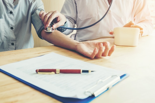 Photo doctor measuring arterial blood pressure woman patient on arm