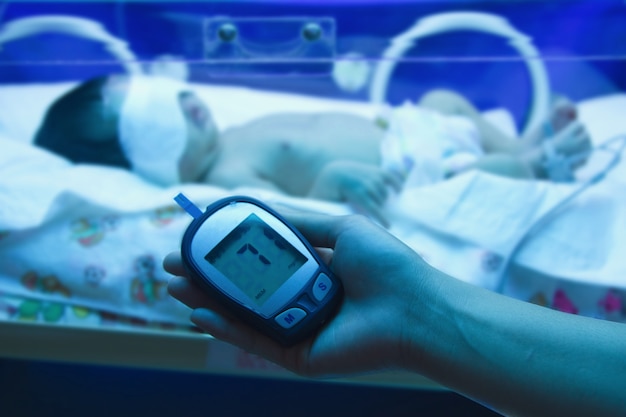 Врач, измеряющий уровень глюкозы в крови у новорожденных
