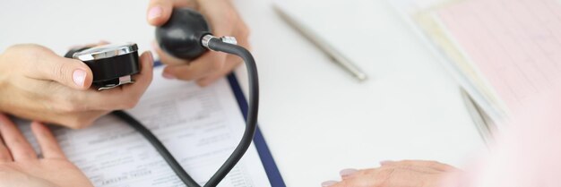 Doctor measuring patients blood pressure with tonometer tool in office