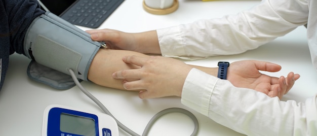 Doctor medical checkup her patient with blood pressure monitor in examination room