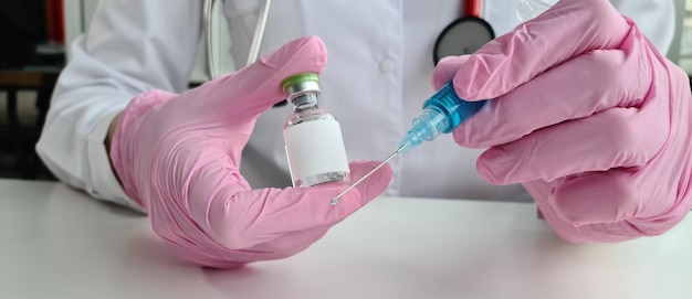 Doctor in medical gloves holds syringe and a vial of ampoule and vaccination