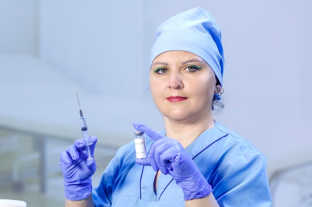 Photo a doctor in medical gloves holds a vial with a vaccine and a syringe