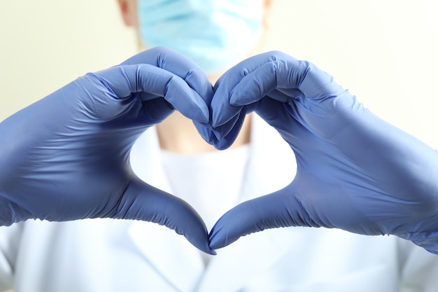 Photo doctor in medical gloves show heart shape