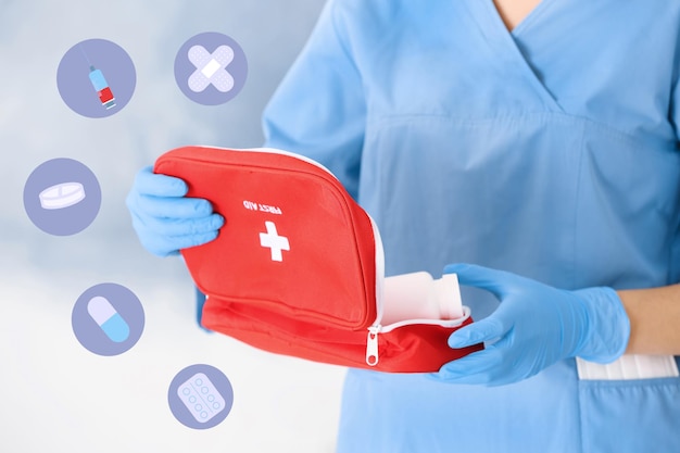 Doctor in medical gloves with first aid kit on blurred background