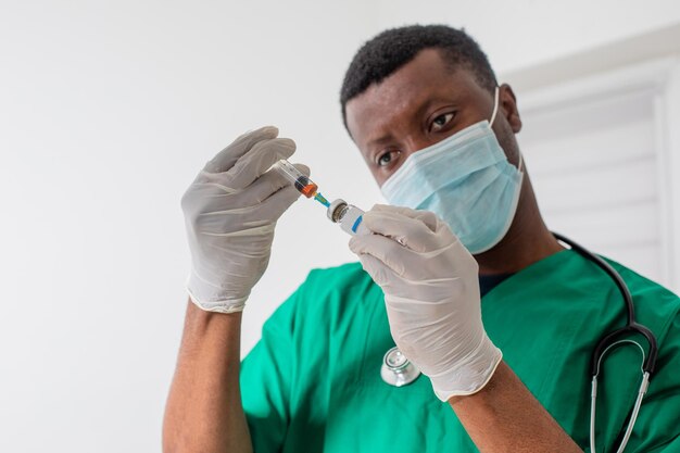 Doctor in medical mask holding syringe with medication