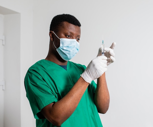 Doctor in medical mask holding syringe with medication