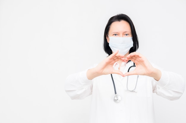 Doctor in medical mask shows heart symbol