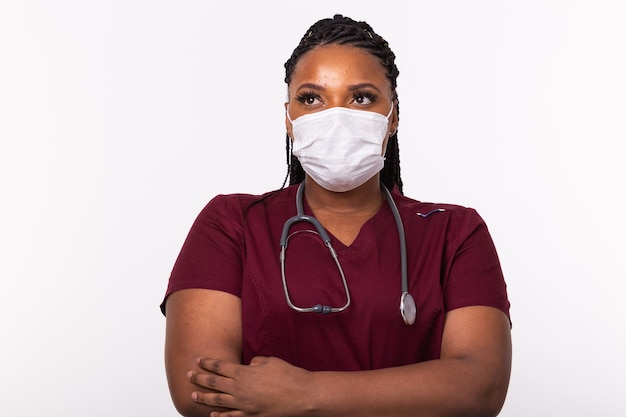 Doctor in a medical mask over white wall