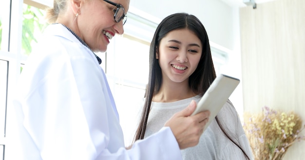 Doctor meeting and explaining medication to woman patient in his office at Hospitals