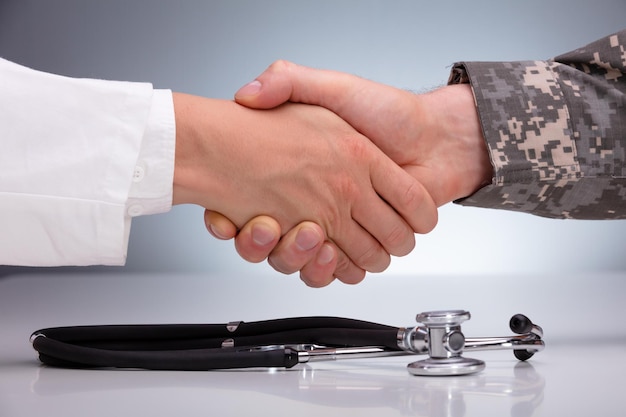 Doctor And A Military Man Shaking Hands Over The Stethoscope