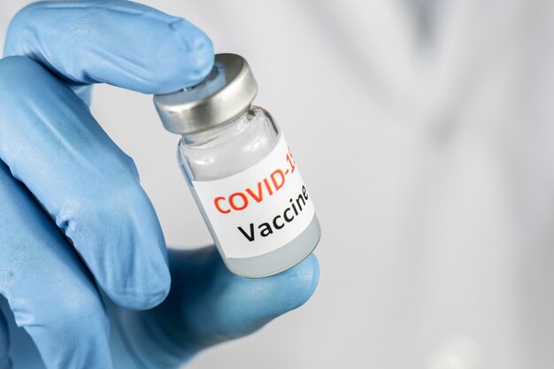 Doctor or nurse hand holding coronavirus vaccine