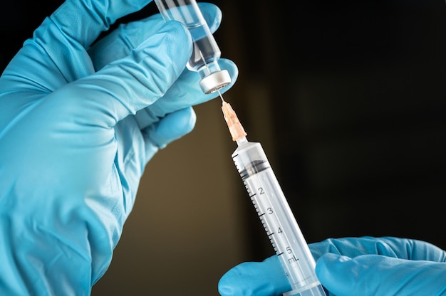 Doctor or nurse hand holding flu vaccine injection 