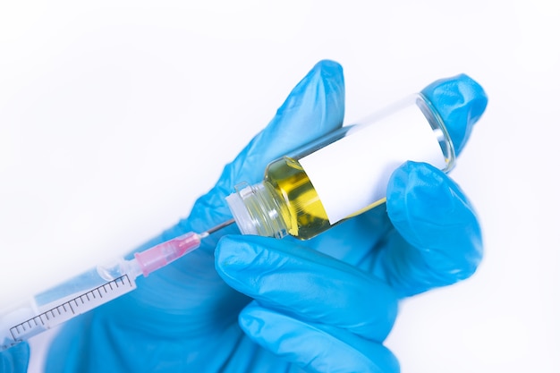 Doctor or nurse health care professional is taking a vaccine into a syringe