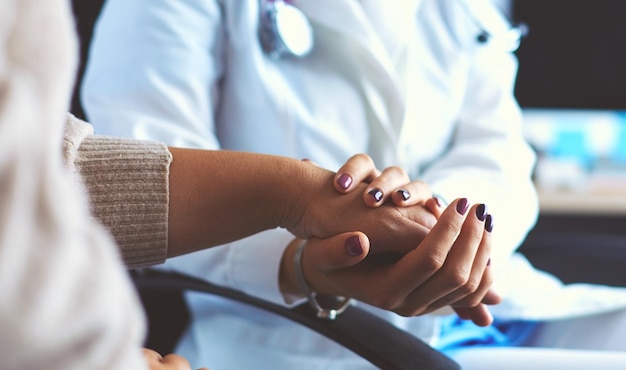 Doctor or nurse holding elderly ladys hands